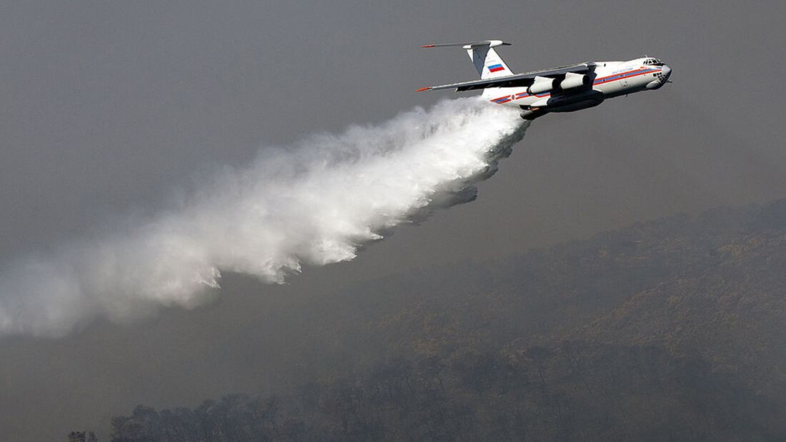 An Ilyushin-76 tanker plane sprays its l
